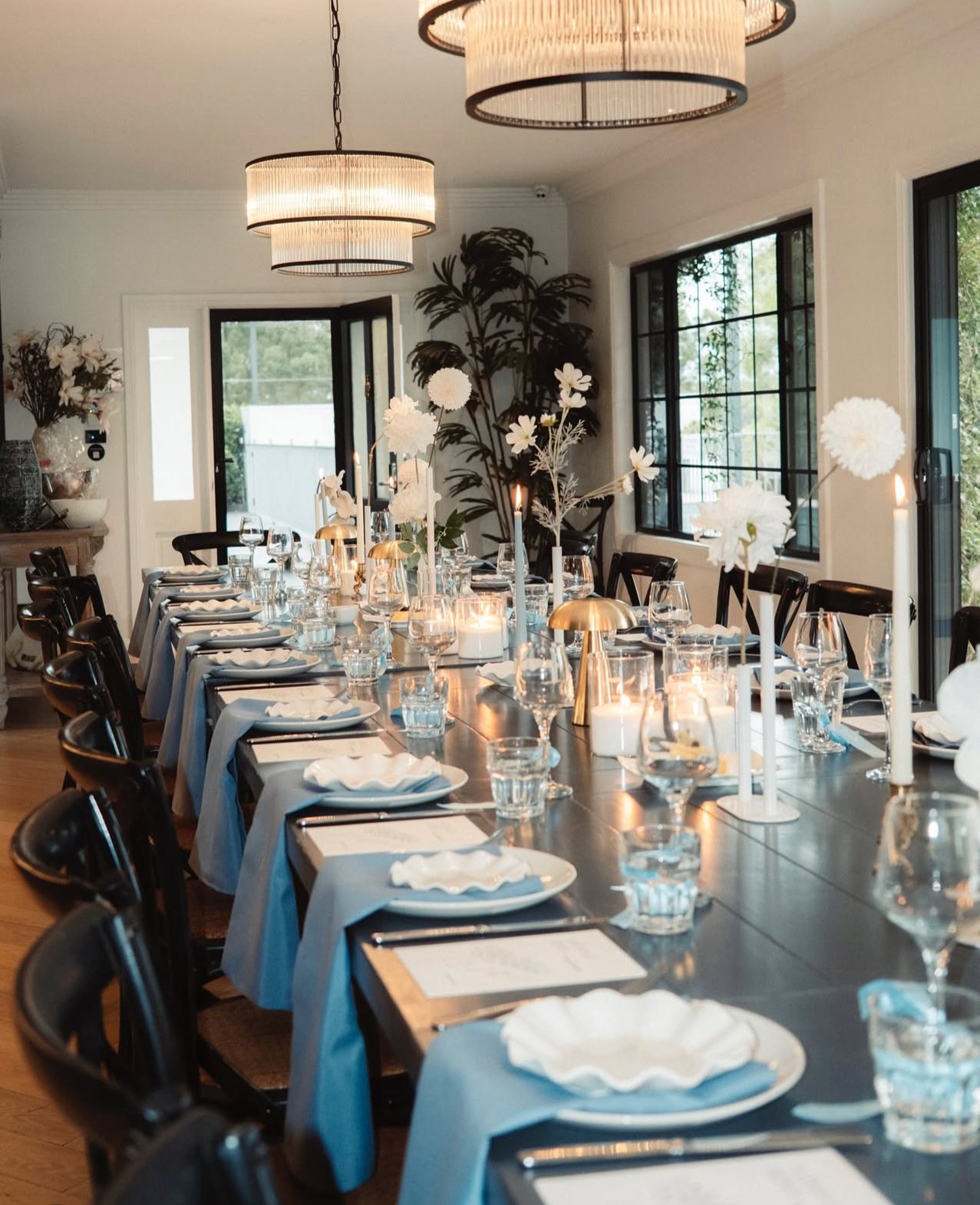 The function room set with long tables, chandeliers and black-framed windows