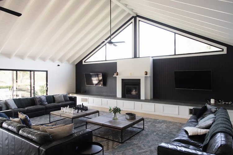 The Main House lounge with black sofas and a vaulted ceiling
