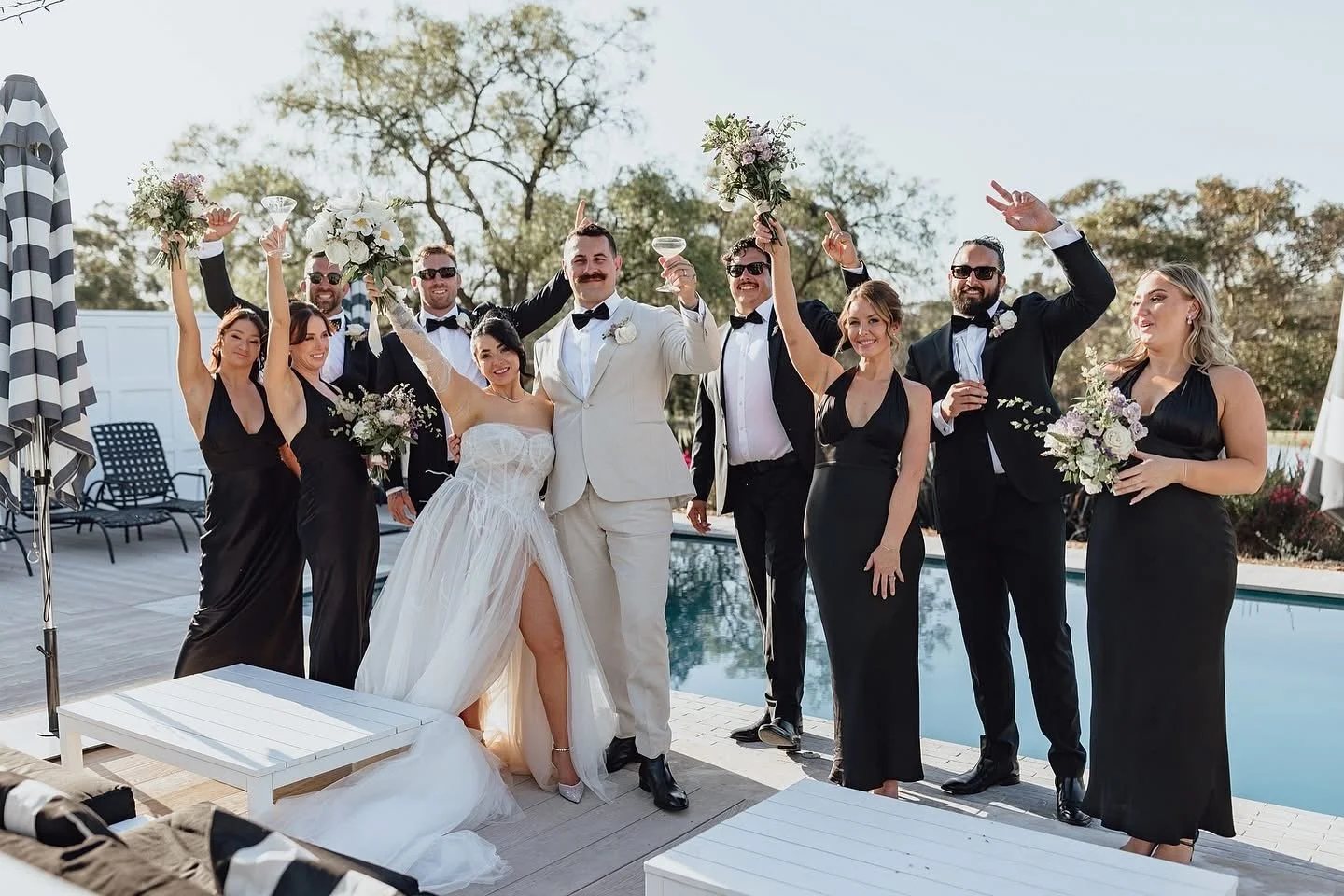 The wedding party cheering by the pool